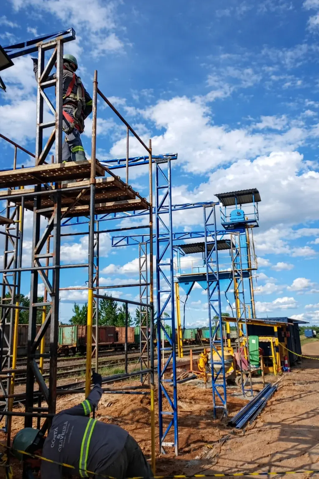 Equipe em serviço ferroviário com andaimes e trabalho em altura